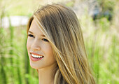 Young woman smiling outdoors, portrait