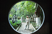 Elderly man wearing traditional Chinese clothing doing Tai Chi