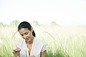 Frau im Feld, Blick auf Blume, Kopf und Schultern