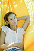 Woman resting in hammock, waist up