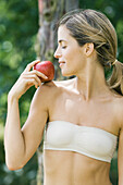 Woman holding apple on shoulder