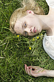 Junge Frau im Gras liegend