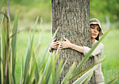 Woman hugging tree with eyes closed