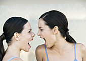 Two young women screaming at each other
