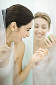 Woman handing friend soap in public showers