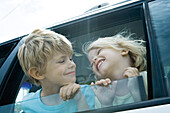 Children sticking heads out of car window