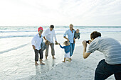 Family on beach, man taking photo