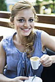 Young woman drinking espresso, portrait