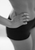 Woman with hand on hip, mid-section, blurred, close-up, B&W.