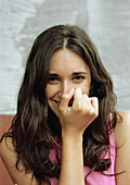 Woman covering mouth with fist, smiling, portrait