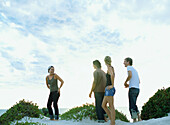 Men and women standing on sand dune