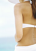 Woman wearing bikini and sun hat, partial view