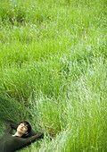 Young woman lying in field