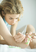 Preteen girl painting toenails