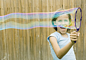 Girl making bubble with wand