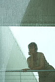 Woman looking through window in rain