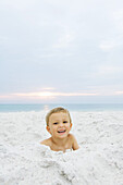Little boy at the beach, smiling at camera, portrait