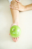 Apple resting in a woman's palm, high angle view