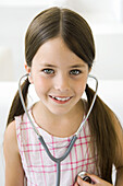 Girl listening to her own heart through stethoscope