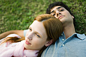 Young couple lying together on lawn, portrait