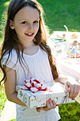 Girl at birthday party holding wrapped gift