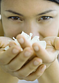 Woman holding gardenia flower in hands, close-up