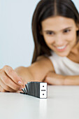 Woman setting off domino chain reaction, focus on foreground