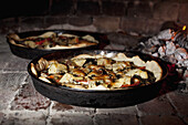 Pizzas cooking in a stone oven