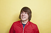 A teenage boy looking off to the side and laughing, portrait, studio shot