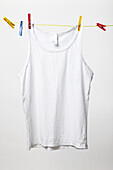 White tank top hanging on clothes line