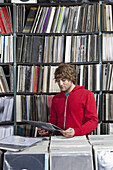 A young man considering a record at a record store