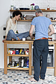 A cheerful mixed age couple preparing food in their kitchen