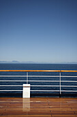 Sun shining on the boat deck of a passenger ship, Canadian coastline in background