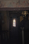 D   Sunbeam through keyhole in church illuminating image of Jesus