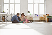 A young hip family playing together on living room floor