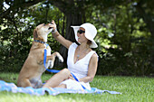 Well dressed woman playing with her dog in park