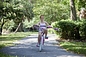 Girl riding bike through park