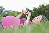 A pregnant woman lying in the grass, side view