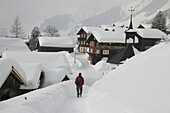 Man strolling through snow covered village