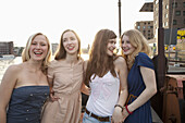 Four female friends standing side by side, Spree River, Berlin, Germany