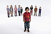 A boy standing in front of a line of kids