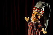 Punch from the puppet show Punch and Judy on stage smiling proudly