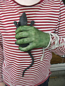 A person with a green hand holding a toy rat