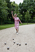 Senior woman plays Boules in the park