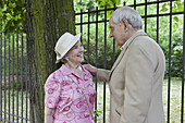 Senior couple, man leans his hand on her shoulder as they look into each other's eyes