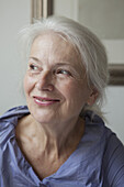 Close-up of smiling senior woman looking away at home
