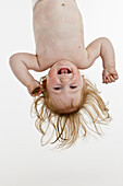 A baby girl held upside down