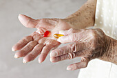 Detail of capsules in the hands of a senior woman