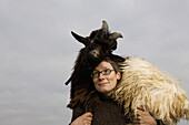 Woman carrying goat on shoulder