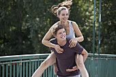 Young man giving woman piggyback ride